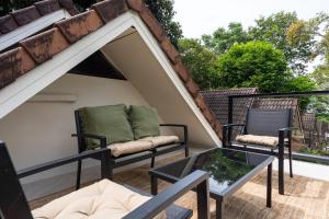 einen Balkon mit 2 Stühlen und einem Glastisch in der Unterkunft The Tropical Boho Bungalow in Phra Ae beach + 22 Fotos