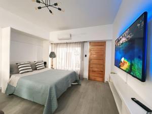 Schlafzimmer mit einem Bett und einem großen TV in der Unterkunft Vivi la comodidad de una casa pensada para vos in Diamante