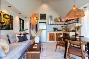 ein Wohnzimmer mit Sofa und Tisch in der Unterkunft The Tropical Boho Bungalow in Phra Ae beach