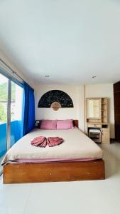 Lucky One Guesthouse في شاطيء باتونغ: غرفة نوم بسرير كبير مع شراشف وردية