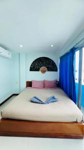 Lucky One Guesthouse في شاطيء باتونغ: غرفة نوم بسرير كبير مع ستائر زرقاء