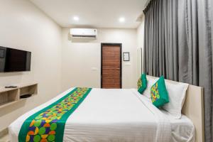 Un dormitorio con una cama grande y un televisor. en Treebo Sea Heights, en Kākināda 33 fotos más