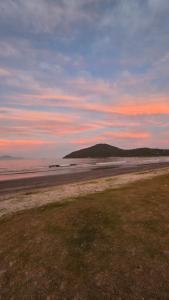 a view of a beach with a hill in the distance at Pousada Flor de Jambo in Ubatuba