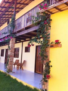 a house with a balcony with flowers on it at Pousada Brisa Do Pontal in Fortim