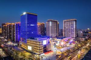 eine Skyline der Stadt bei Nacht mit hohen Gebäuden in der Unterkunft Lavande Hotel Xuchang Pangdonglai Hengdajinhui Plaza in Xuchang