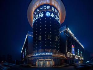 un grand bâtiment avec un panneau dessus la nuit dans l'établissement Lavande Hotel Changsha South High-speed Railway Station Xiyingmen, à Changsha