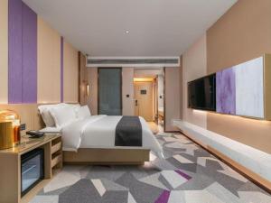 a bedroom with a large bed and a flat screen tv at Lavande Hotel Chaozhou Fortune Center Lin Street in Fengxi +223 photos