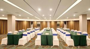 une salle de banquet avec des tables vertes et des chaises blanches dans l'établissement Lavande Hotel Changsha South High-speed Railway Station Xiyingmen, à Changsha