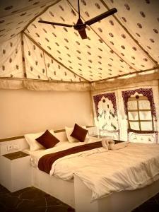 sypialnia z dwoma łóżkami i wentylatorem sufitowym w obiekcie Patel Heritage Resort w mieście Jaisalmer +4 zdjęcia