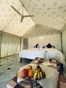 pokój z łóżkiem i stołem, na którym stoją owoce w obiekcie Patel Heritage Resort w mieście Jaisalmer