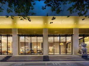a building with large glass windows and a statue at Borrman Hotel Golden Crown Liuzhou Wuxing Pedestrian Street in Liuzhou