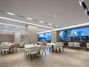 a dining room with tables and chairs in a building at Borrman Hotel Golden Crown Liuzhou Wuxing Pedestrian Street in Liuzhou