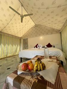 Pokój z 2 łóżkami i tacą z owocami na stole w obiekcie Patel Heritage Resort w mieście Jaisalmer