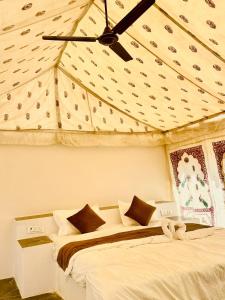sypialnia z dwoma łóżkami i wentylatorem sufitowym w obiekcie Patel Heritage Resort w mieście Jaisalmer