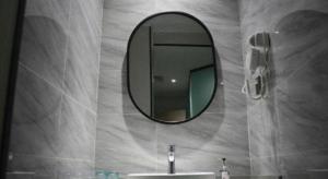 a bathroom with a mirror and a sink at Borrman Hotel Ji'an Railway Station Jinggangshan University in Ji'an