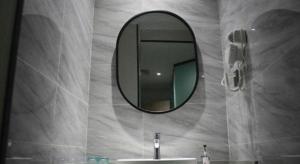 a bathroom with a mirror and a sink at Borrman Hotel Ji'an Railway Station Jinggangshan University in Ji'an