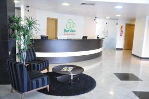 a lobby with a waiting area with two chairs and a table at Boa Vista Eco Hotel in Boa Vista