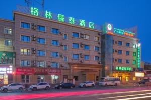 a large building with cars parked in front of it at Green Tree Inn Urumqi San'gong Metro Station Exit in Ürümqi