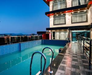 a swimming pool on the roof of a building at Hotel Meriken in Dharān Bāzār