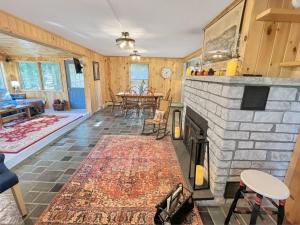 ein Wohnzimmer mit einem Steinkamin und einem Tisch in der Unterkunft The Rosewood home in Bomoseen
