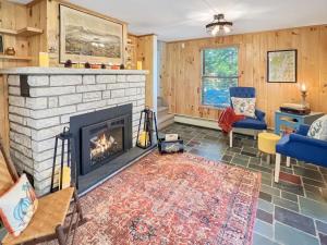 ein Wohnzimmer mit einem Kamin und einem blauen Stuhl in der Unterkunft The Rosewood home in Bomoseen
