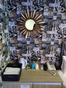 einen Spiegel an der Wand in einem Zimmer mit einem Schreibtisch in der Unterkunft E Lim Hotel in Zhongli