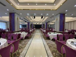 ein Bankettsaal mit Tischen und lila Stühlen in der Unterkunft Vienna Hotel Guangdong Dongguan Zhongtang Qunying Road in Zhongtang