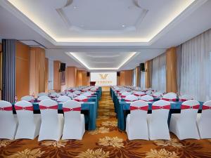 une salle de banquet avec des tables et des chaises dans une pièce dans l'établissement Vienna Hotel Kunming Beijing Road Chuanxin Gulou Metro Station, à Kunming