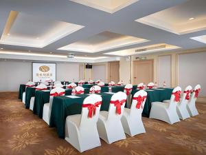 ein Konferenzraum mit grün-weißen Tischen und weißen Stühlen in der Unterkunft Vienna Hotel Guangdong Foshan West Station Airport Luocun in Huanshi