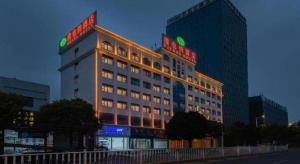 a hotel building with neon signs on top of it at Vienna Hotel Ganzhou Economic Development Zone 1st Hospital West High-Speed Railway Station in Ganzhou