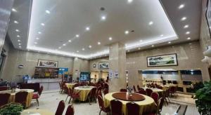 a restaurant with tables and chairs in a room at Vienna Hotel Ganzhou Economic Development Zone 1st Hospital West High-Speed Railway Station in Ganzhou