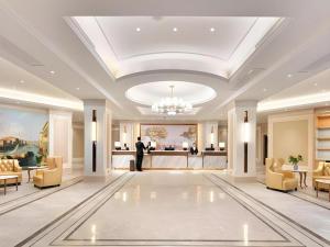 a lobby with a chandelier and a man standing in the middle at Vienna Hotel Yongzhou Dong'an High-Speed Railway Station in Guzhuting