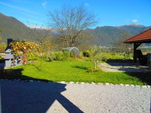 a shadow of a building and a garden with mountains at Apartma R Sport in Tolmin