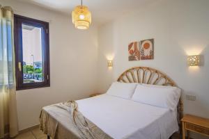 a bedroom with a white bed and a window at Residence Borgo Latino- Localo in Torre dell'Orso