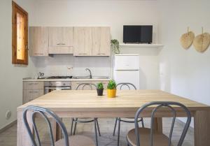 a kitchen with a wooden table and chairs at Residence Borgo Latino- Localo in Torre dell'Orso