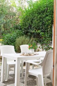 een witte tafel en stoelen op een patio bij Residence Borgo Latino- Localo in Torre dell'Orso +34 foto's