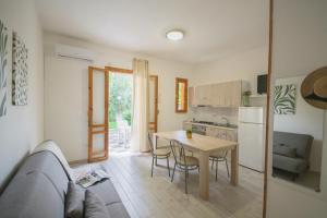 a living room with a table and a kitchen at Residence Borgo Latino- Localo in Torre dell'Orso