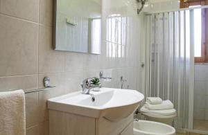 een badkamer met een wastafel, een toilet en een spiegel bij Residence Borgo Latino- Localo in Torre dell'Orso