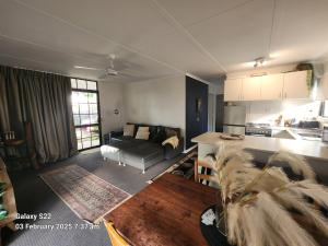 a living room with a couch a table and a kitchen at Corindi Beach Pad in Arrawarra