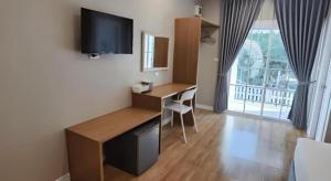 a room with a desk with a computer and a window at Thong Prachok Hotel in Sakon Nakhon
