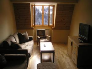 a living room with a couch and a table at Apartman 205- Aparthotel Vučko Jahorina private host 50m2 in Jahorina +3 photos
