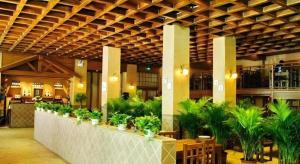 Un vestíbulo con un largo mostrador con plantas en macetas. en GreenTree Inn Luoyang Henan University of Science and Technology, en Luoyang