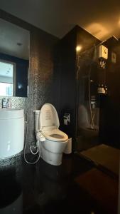 a bathroom with a white toilet and a shower at Modern Bangkok Apartment Train Access in Bangkok
