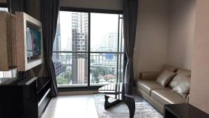a living room with a couch and a large window at Modern Bangkok Apartment Train Access in Bangkok