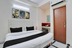 a bedroom with a large white bed and a brown door at Super Hotel O DLF Phase 1 Metro Station Gurugram in Gurgaon +30 photos