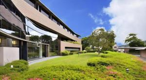 eine Außenansicht eines Gebäudes mit einem grünen Hof in der Unterkunft Corredor Yugawara Dog＆Resort in Miyakami