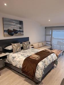 ein Schlafzimmer mit großem Bett und Balkon in der Unterkunft Breede River Lodge in Witsand + 285 Fotos