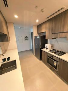 une cuisine avec des appareils en acier inoxydable et une cuisinière dans l'établissement Yas F1 1 bedroom apartment, à Abu Dhabi 4 autres photos