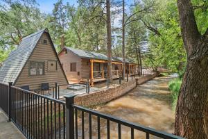 a log cabin with a fence next to a river at Timber Lodge #7 in Colorado Springs