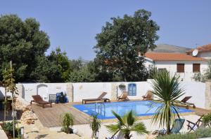 uma piscina com cadeiras e uma cerca branca em Villa Olma em Trogir